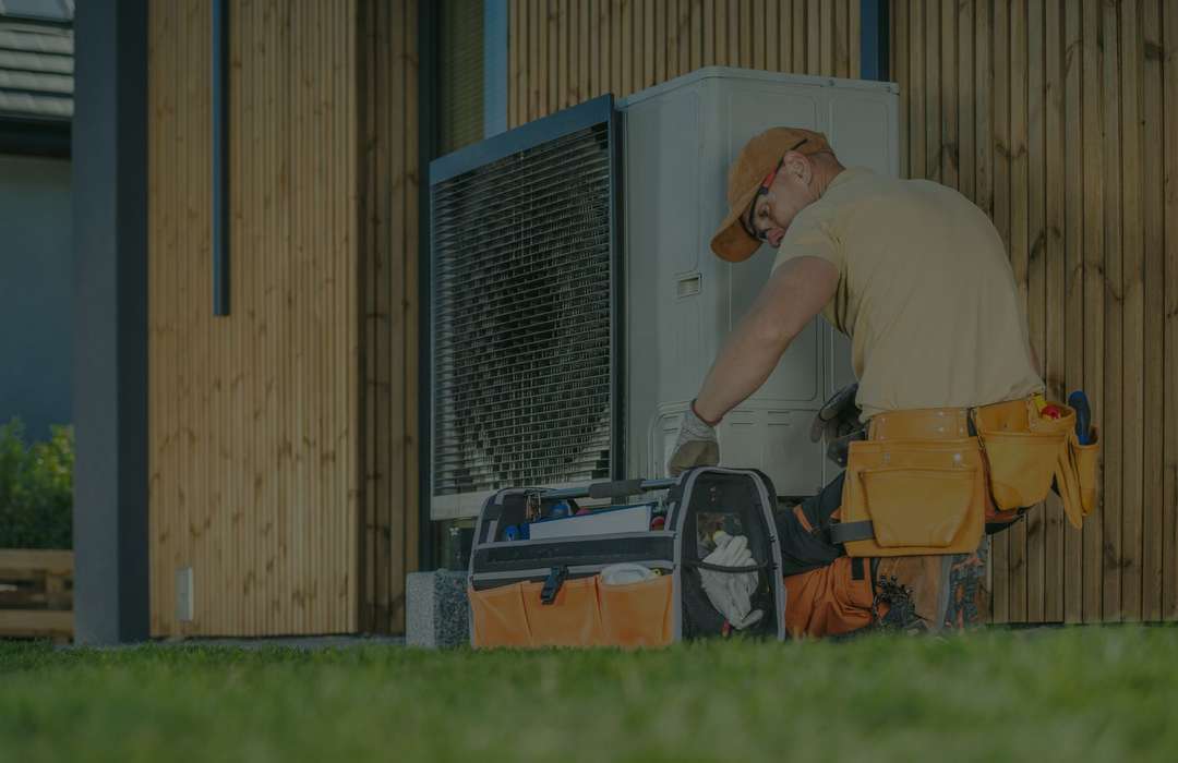 HVAC technician servicing an outdoor heat pump at a Forney area home