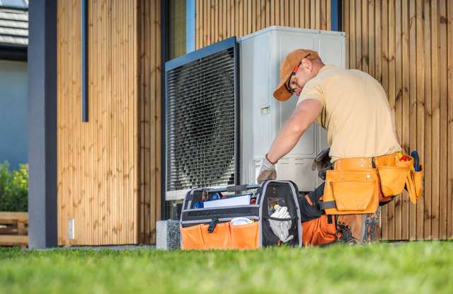 HVAC technician installing a new outdoor heat pump unit